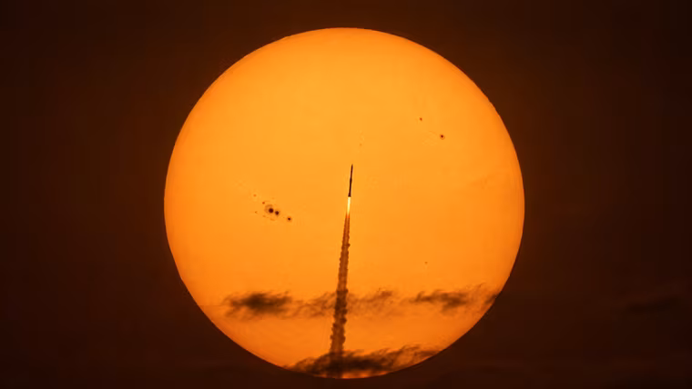 Raketa se třemi sondami proletěla na snímku přes sluneční kotouč