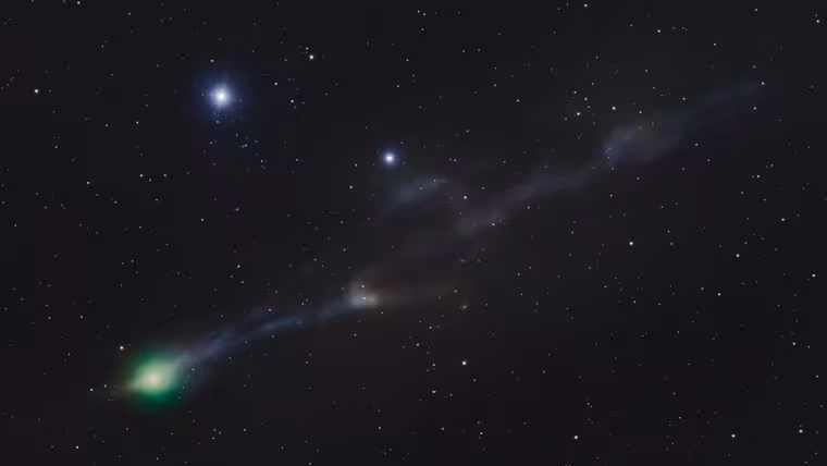 Zelená koma komety 3I ATLAS s modrým iontovým ohonem a slabým protiohonem