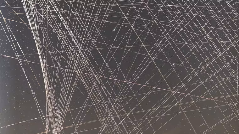 Kometa R3 PanSTARRS mezi mnoha světelnými stopami družic na dlouhé expozici